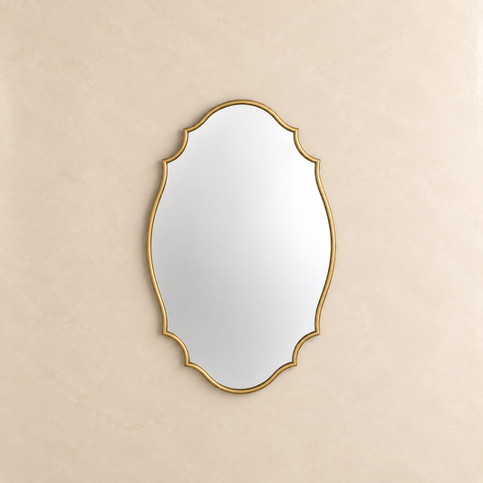 An ornate oval wall mirror with a gold scalloped frame, mounted on a textured beige wall.