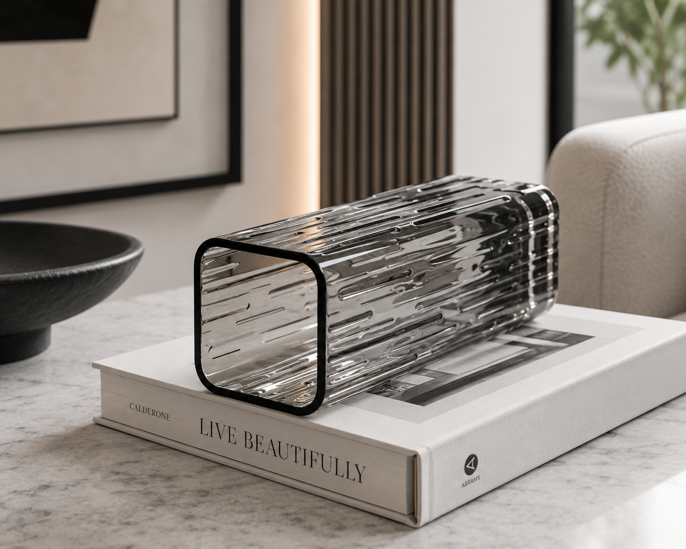 Smoked Crystal Vase on its side on a book which is on a coffee table beside a bowl
