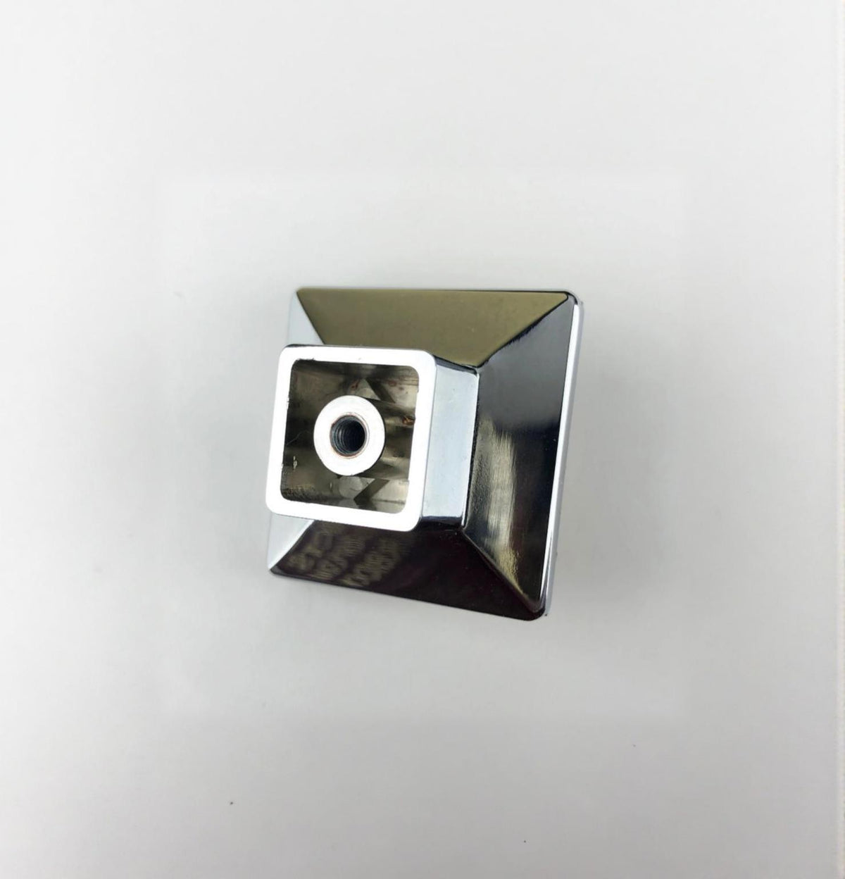 Shiny square crystal knob with faceted edges and a central hole for mounting on cabinets or drawers