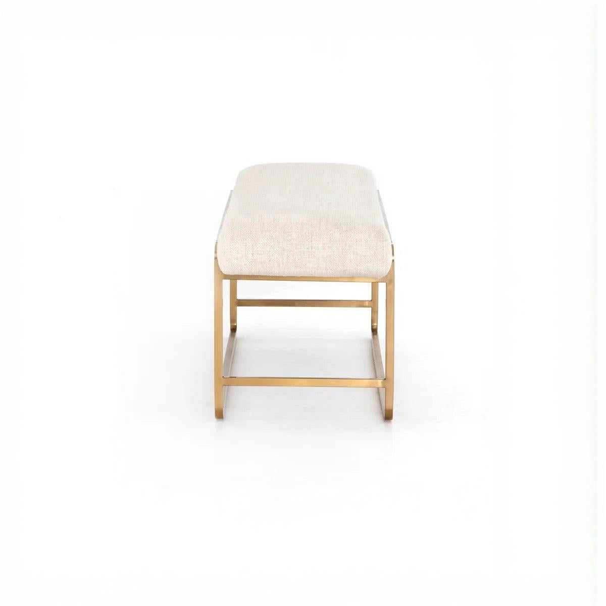 Ivory upholstered bench with brass-finished steel frame and bullnose edging on a white background