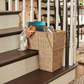 Load image into Gallery viewer, Wicker brown storage basket shaped for stairs holding books and a patterned scarf on wooden staircase steps
