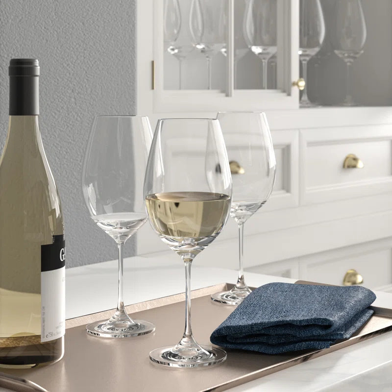wine glass set on table with wine bottle and cloth napkin