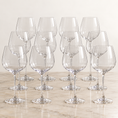 Load image into Gallery viewer, wine glass set arranged in rows on a light marble surface against a warm off-white background.
