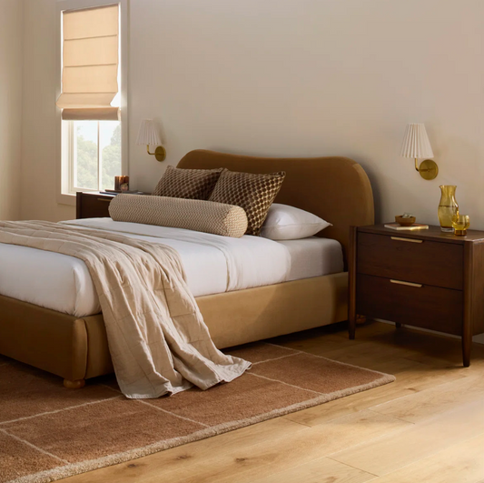 wood nightstand in bedroom next to bed with a glass on it and a book