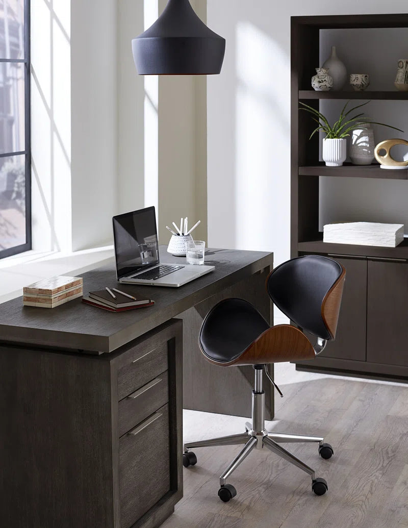writing desk in at-home office with a computer on it and shelving next to it