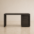 Load image into Gallery viewer, A modern dark wood writing desk with a three-drawer pedestal cabinet on the right side, featuring slim horizontal metal handles, set against a warm beige textured wall and marble floor.

