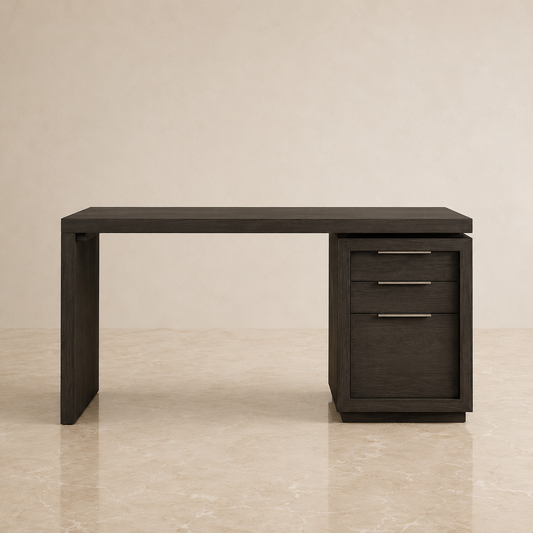 A modern dark wood writing desk with a three-drawer pedestal cabinet on the right side, featuring slim horizontal metal handles, set against a warm beige textured wall and marble floor.